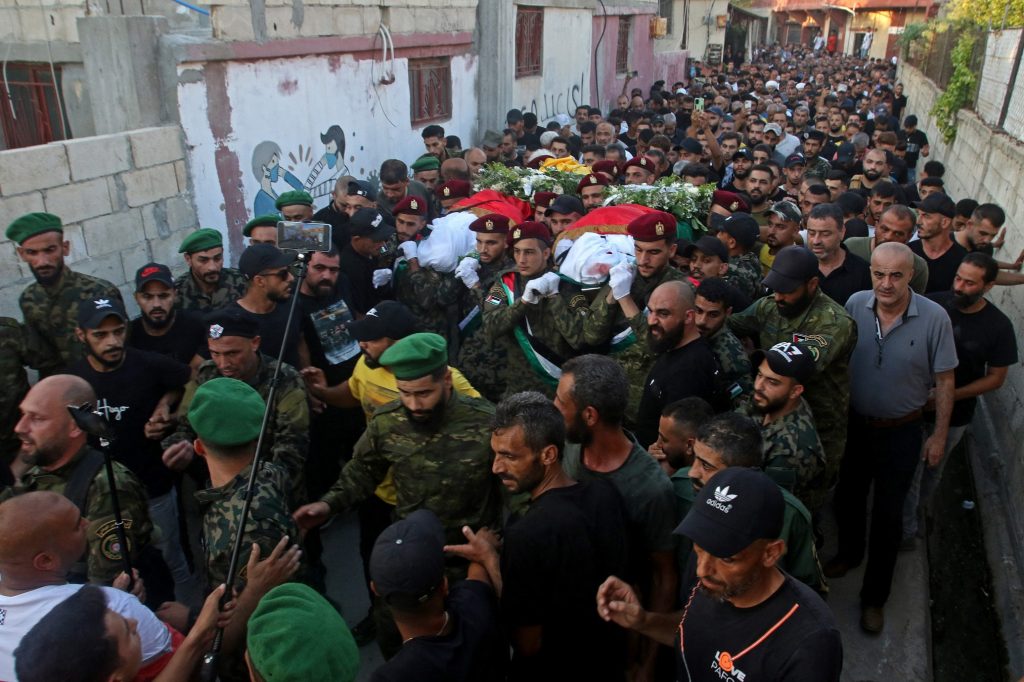Mourners carry the bodies of Fatah movement commanders Ashraf al-Armuchi and Mussa Fandi during their funeral at the Rashidieh Palestinian refugee camp in the southern Lebanese port city of Tyre on July 31, 2023. Fighting broke out over the weekend between members of Palestinian president Mahmud Abbas's secular Fatah movement and Islamist militants based in the camp located in the coastal city of Sidon. (Photo by Mahmoud ZAYYAT / AFP)